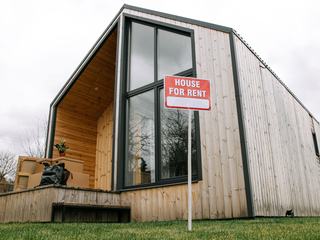 Façade en bardage bois vertical d'une maison individuelle, vue depuis le jardin
